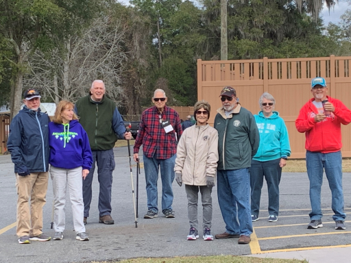 Group standing distanced slightly from one another in a parking lot.